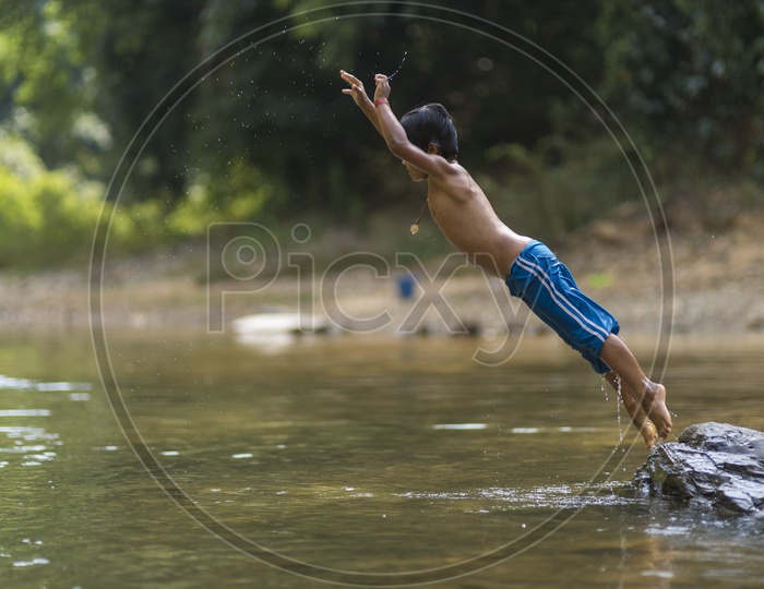 A Burmese kid diving in a river.