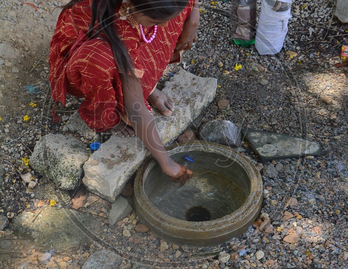 Young Girl Child  Filling  Drinking Water to Bottles From a Overflowing Pipeline In Hyderabad City