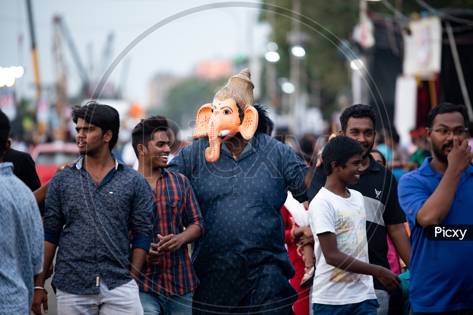 Indian Stout Man Wearing  Lord Ganesh Mask  and Walking Along The Tankbund Roads During Ganesh Idols Immersion or Visarjan Event