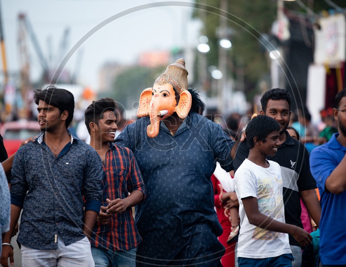 Indian Stout Man Wearing  Lord Ganesh Mask  and Walking Along The Tankbund Roads During Ganesh Idols Immersion or Visarjan Event