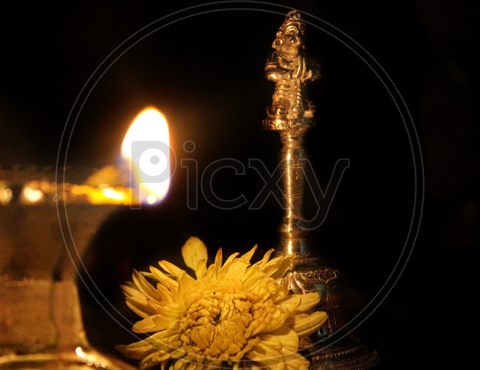 Oil diya with a flower beside.