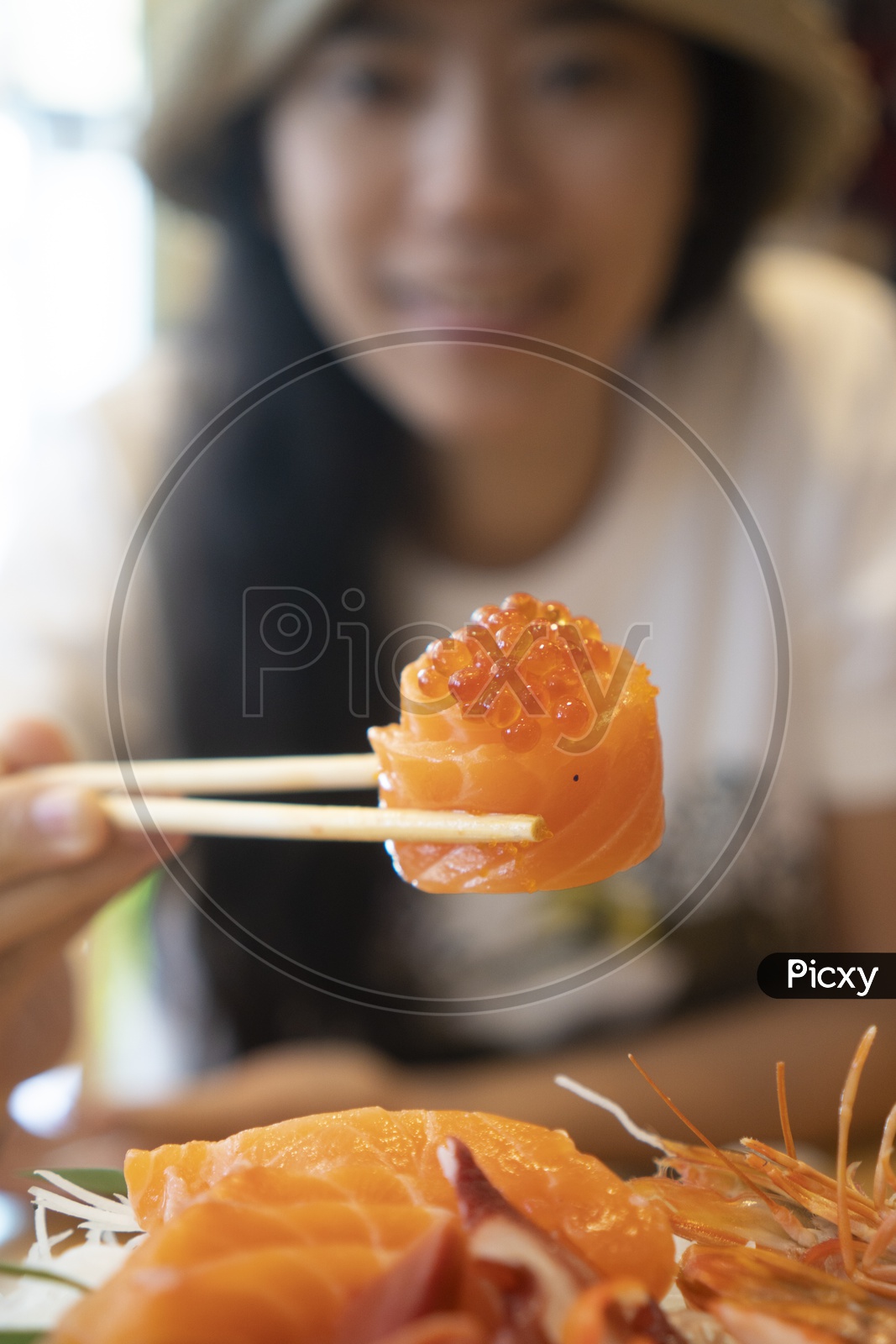 Young Woman Eating Salmon roe Sushi, Japanese food