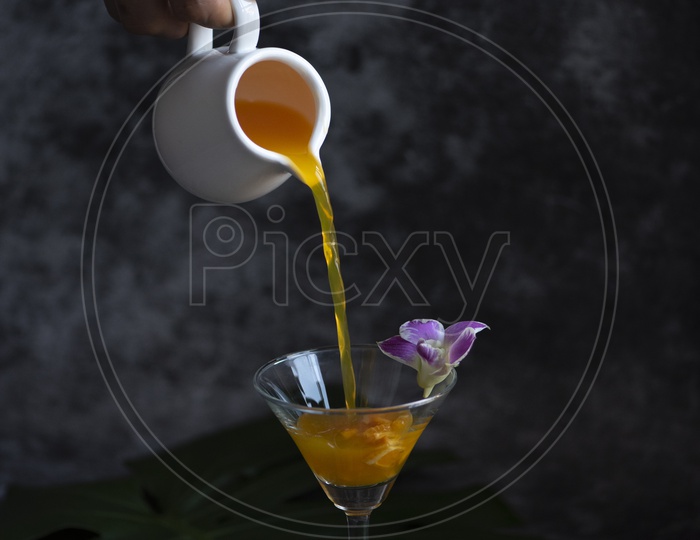 orange cocktail pouring in glass