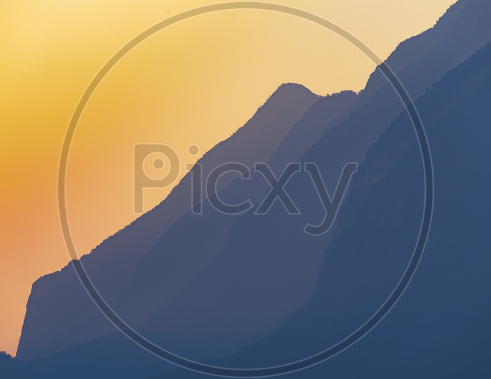 Sunset Over Mountain Layers With Golden Sun light Flare