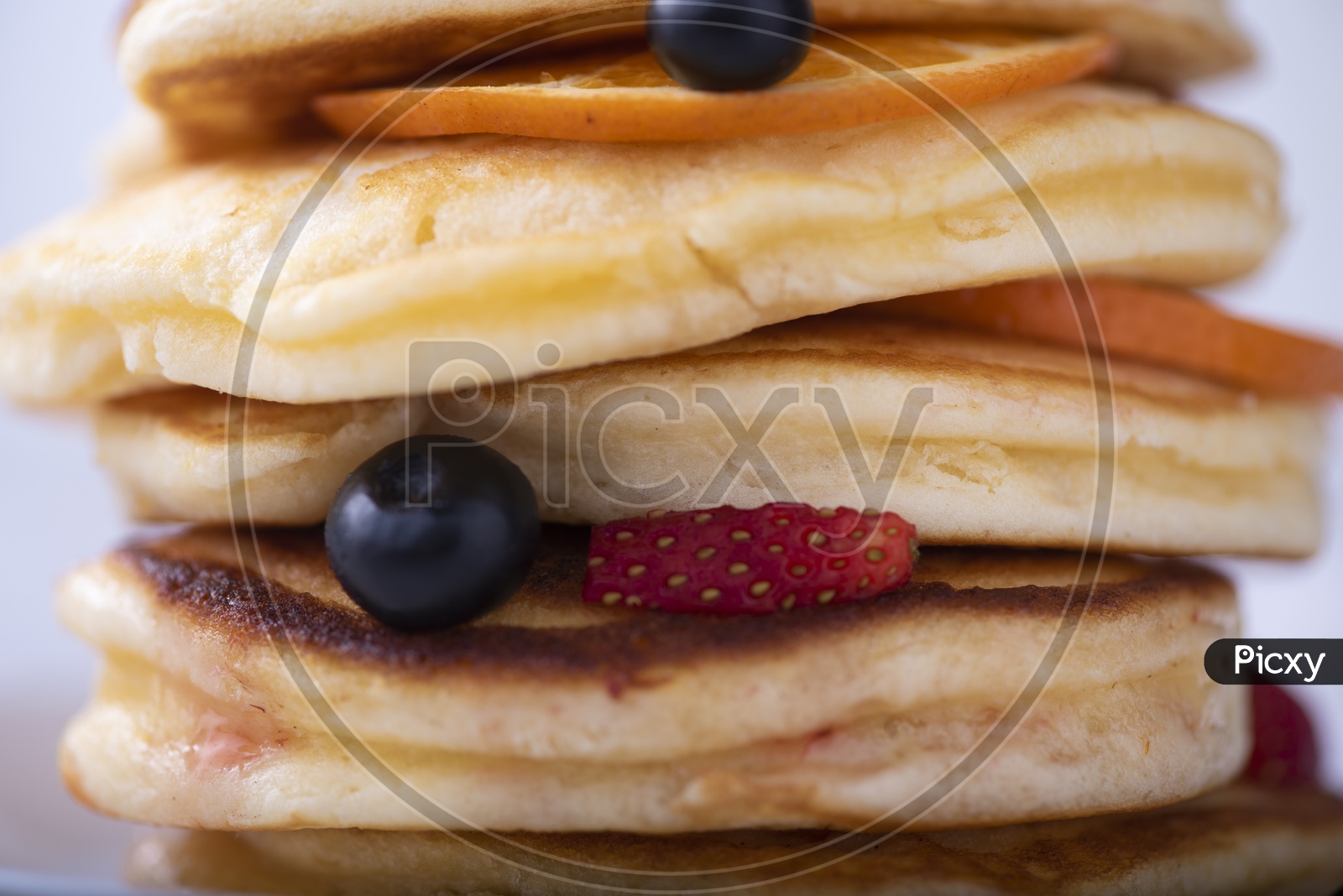 pancake stack with strawberry, blueberry, and orange