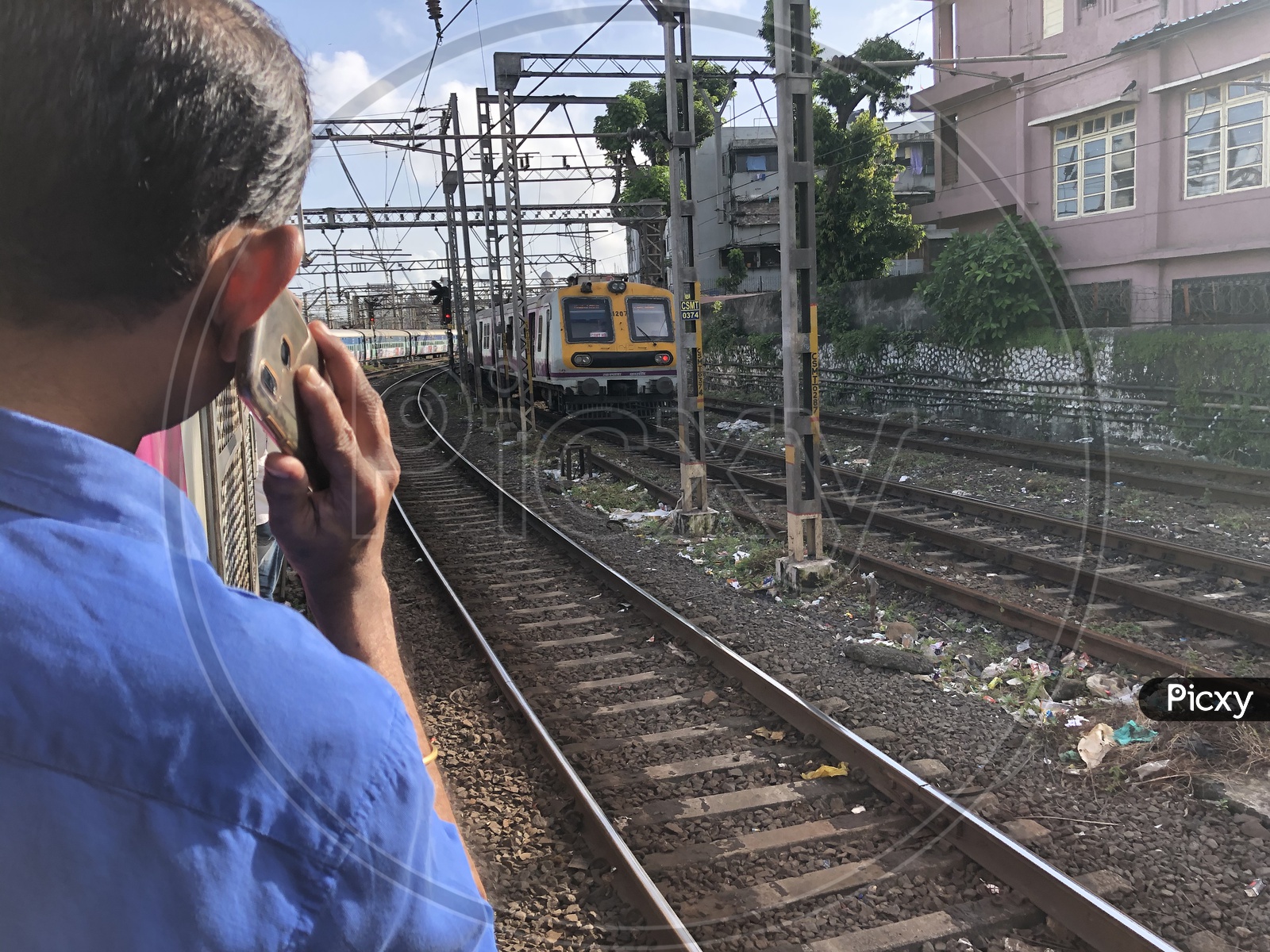 Indian Man Speaking In Phone While Travelling In  Mumbai Local Train Standing at Door Step