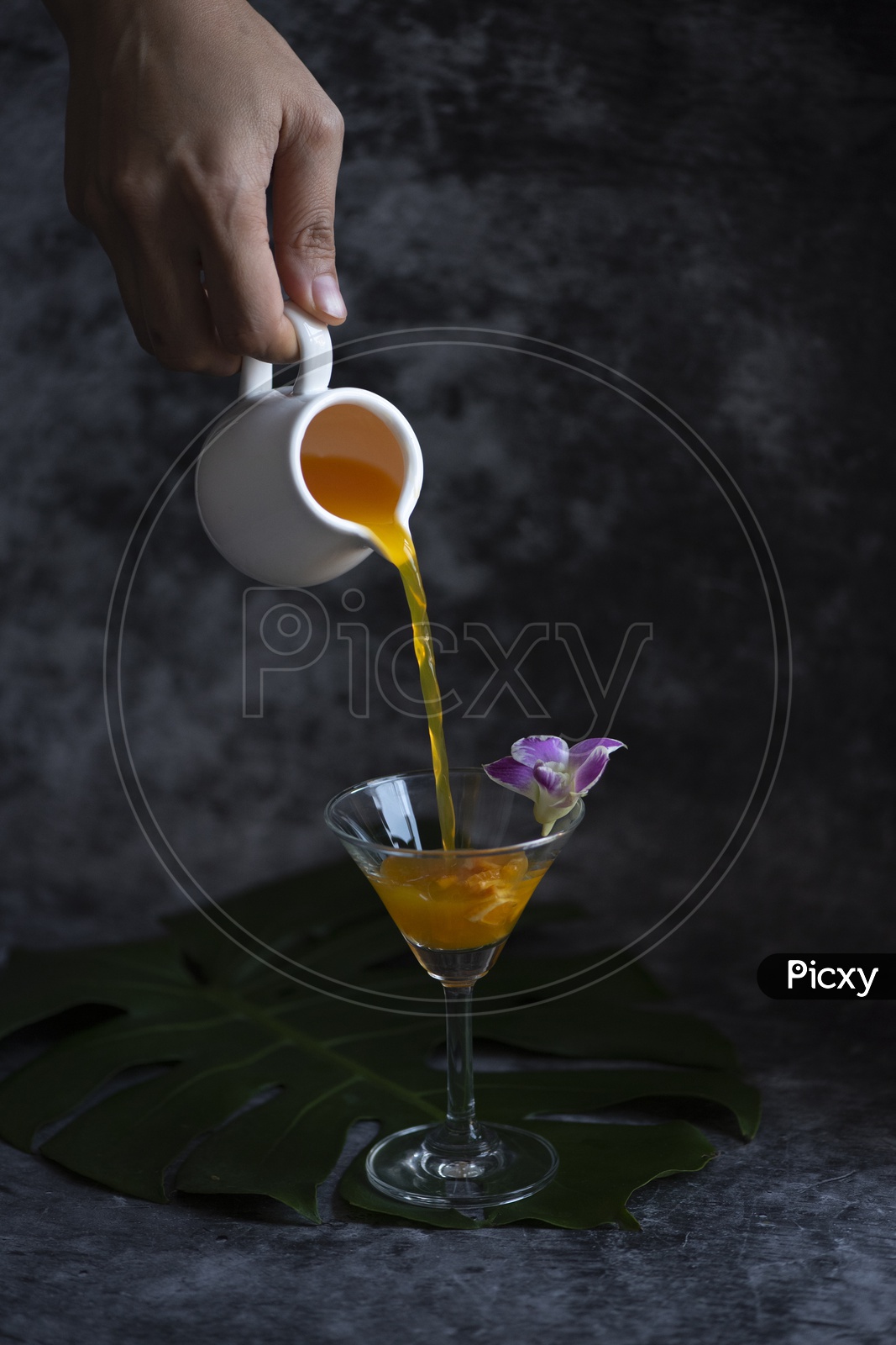 orange cocktail pouring in glass