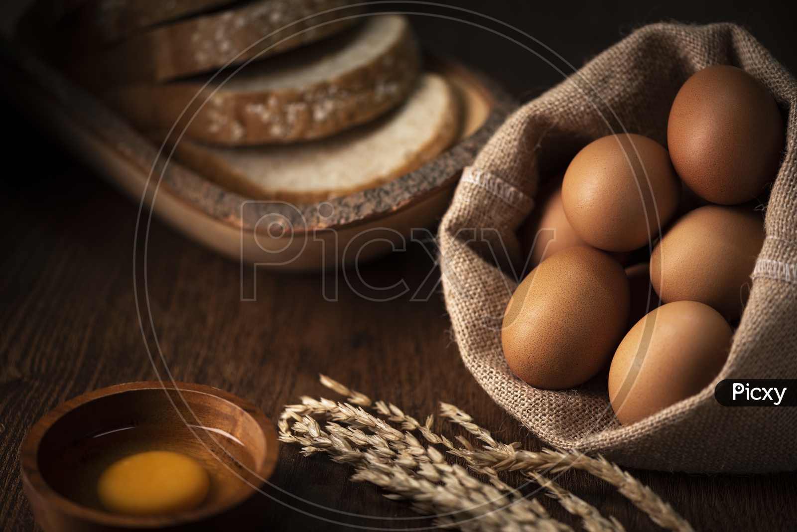 Brown Eggs in Sack, Broken Egg with yolk in Background