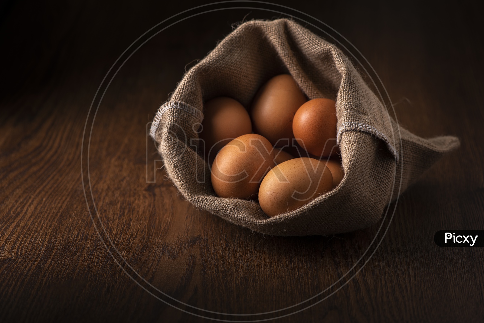 Fresh Brown Eggs in Sack Bag on Wooden Background