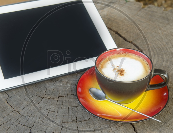 digital tablet and coffee cup on wooden table