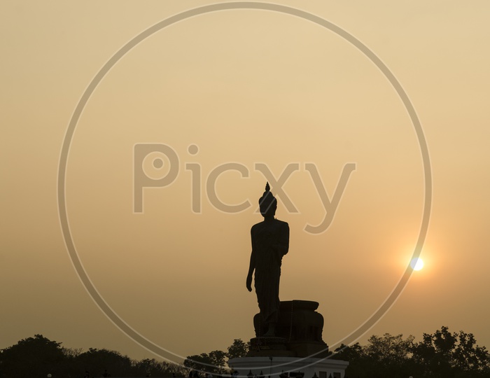Silhouette Of Buddha Statue With Sunset Sky in Buddhist Park in Phutthamonthon District , Buddha Monthon , Nakhon Pathom , Thailand