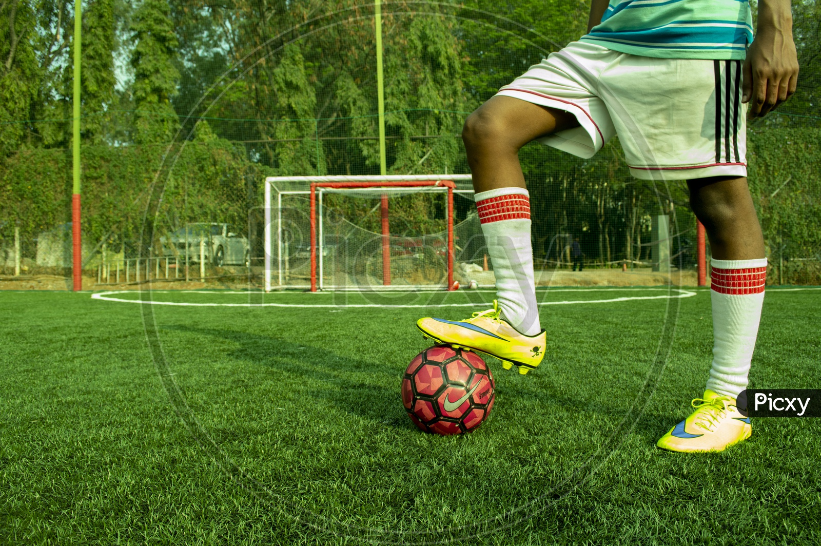 A football player ready to take a strike on plastic football turf.