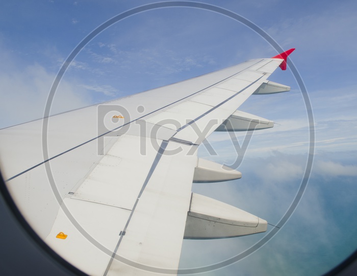 Airplane wing in the blue sky with white clouds Views From  Flight Windows