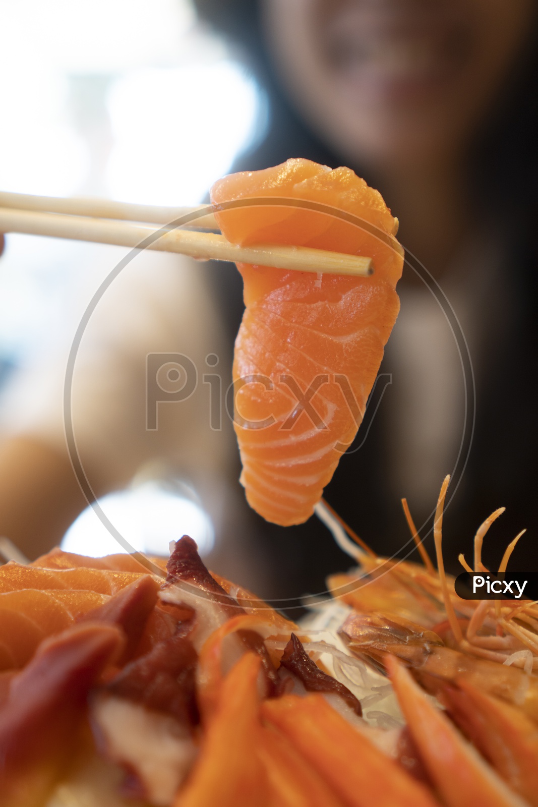 Young Woman Eating Salmon Sashimi, Japanese food