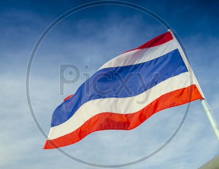 Thai Flag Waving  On Flag Pole With  Blue Sky Background