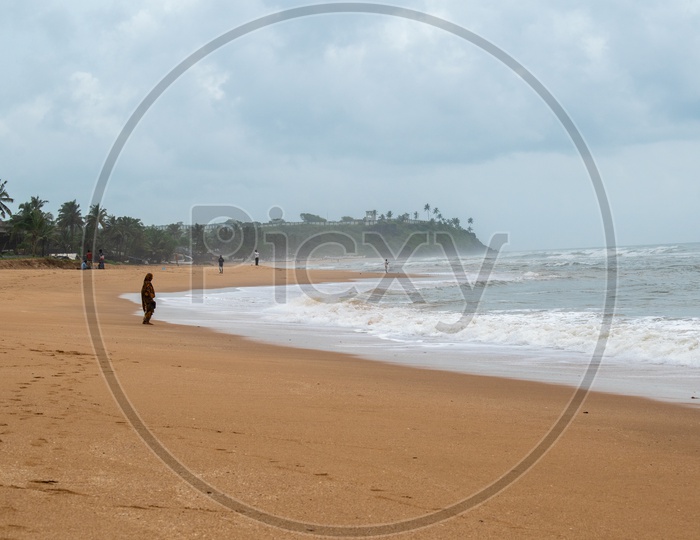 An old woman standing at Baina beach, Goa.