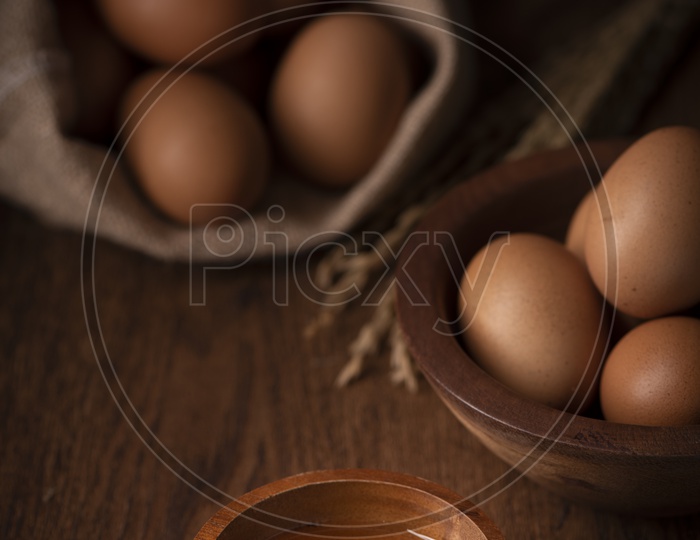Brown Eggs in Sack, Broken Egg with yolk in Background