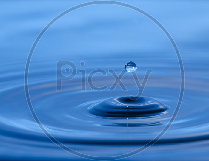 Water drop Splash Over Blue Water Surface   Forming a Background