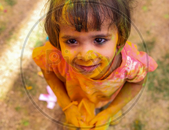 small girl playing holi