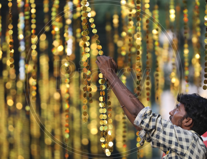 Indian Man arranging the hanging decorations
