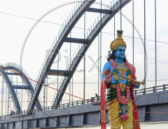 Lord Krishna Statue With Godavari Arch Bridge In Background