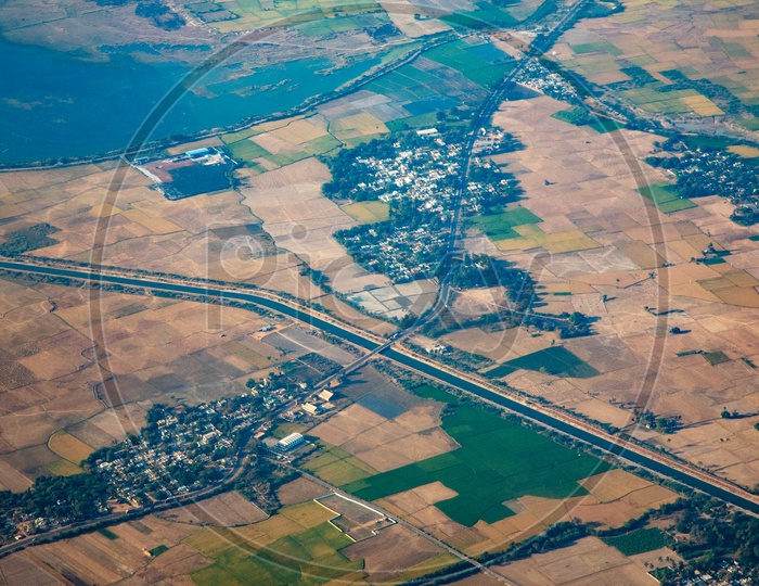 Aerial View Of Green Paddy Fields And  Roads  From Flight Window