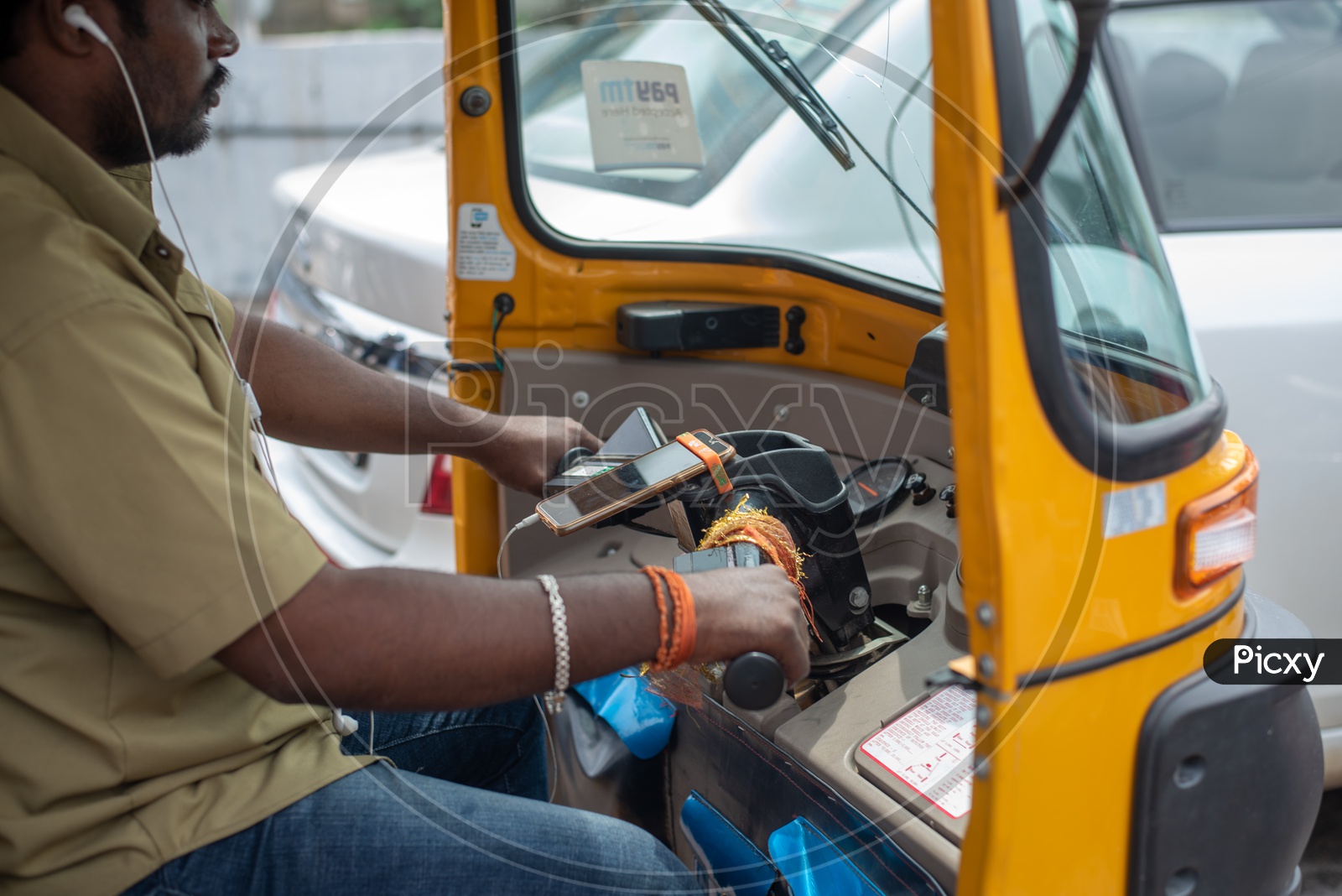 Auto Driver Riding Auto By Putting On Earphones