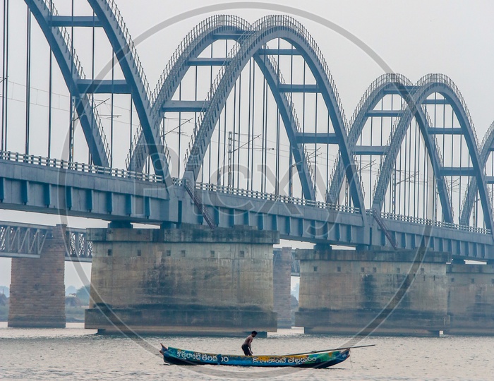 Fisherman in Fisher Boat With Godavari Arch Bridge  in Background