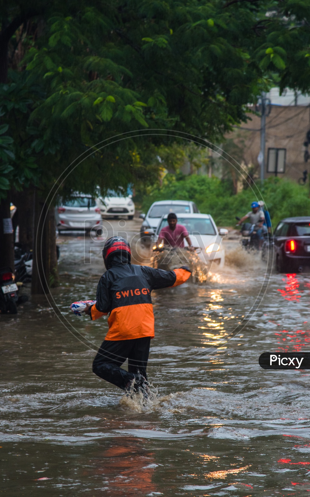 Swiggy Delivery Boy delivering food in rain flooded water on road