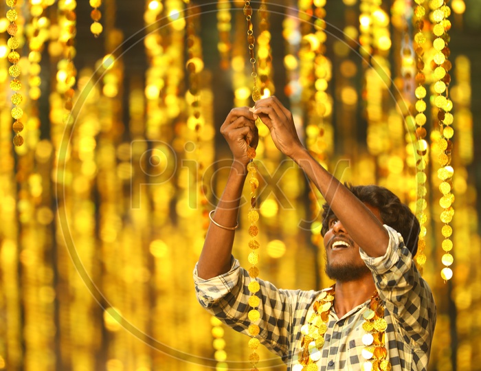Indian Man setting up the hanging decorations during the night