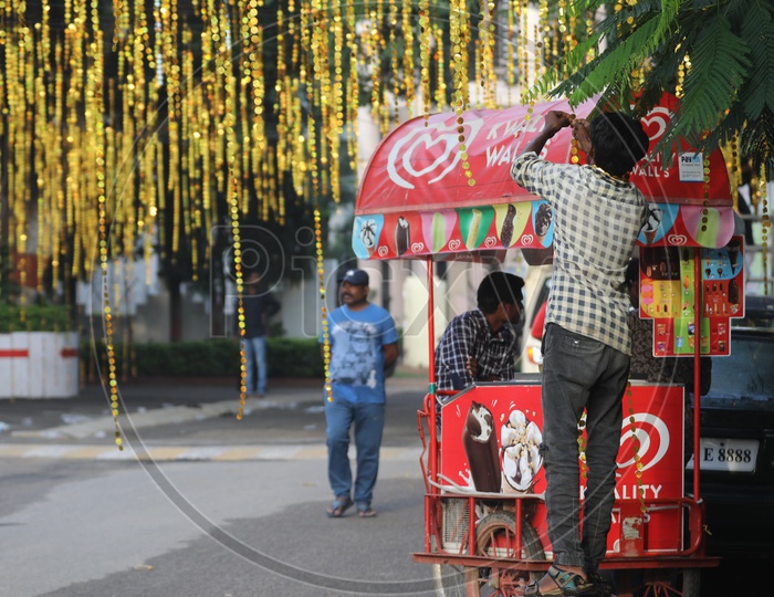 Indian Man setting up the decorations by taking help of the Ice Cream Vehicle