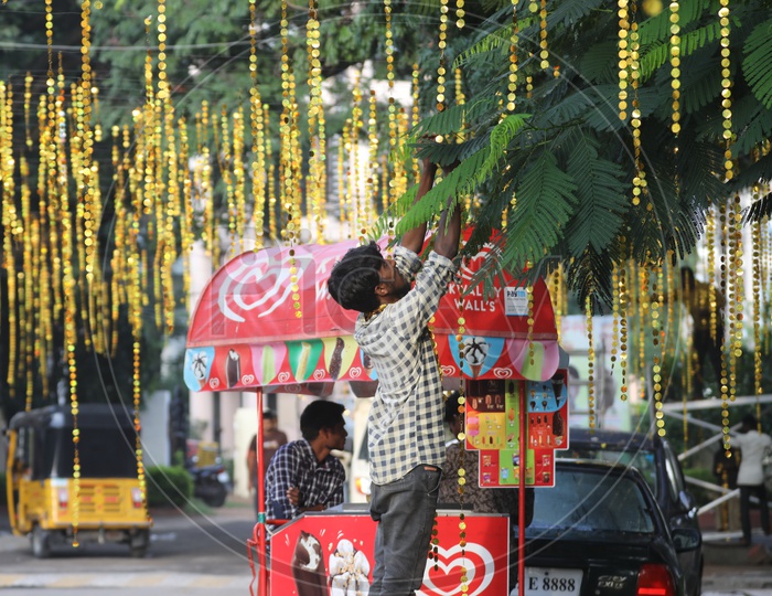 An Indian Man setting up the decorations along the road