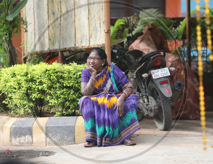 Indian Woman sitting on the block by the garden