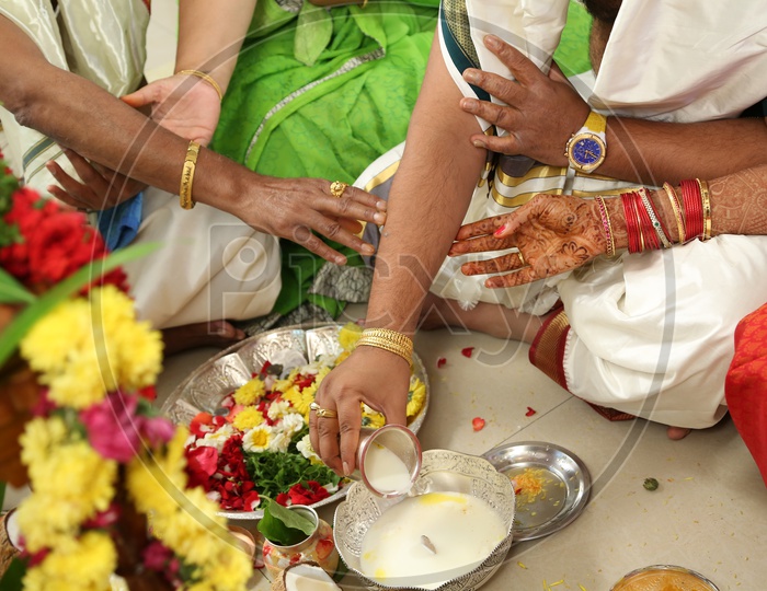 Indian Man pouring milk during pooja