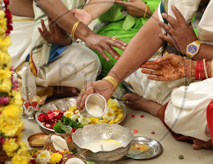 Indian Man pouring milk during Pooja