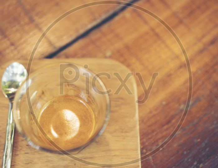 Coffee Drip in a Glass over Wooden Background