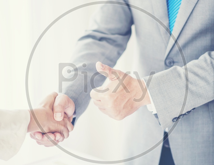 Business Success Greetings Concept With Business Partners Shaking Hands And Thump up Gesture Closeup Hands closeup