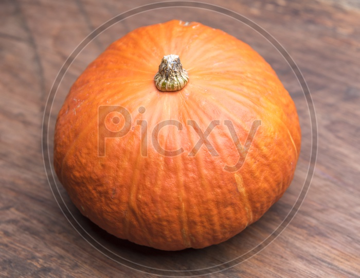 Giant orange pumpkin on wooden table background