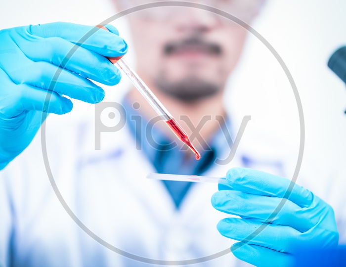Male Asian Scientist Experimenting with Blood Sample in Laboratory