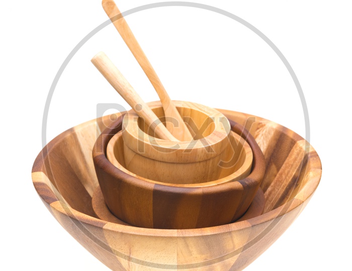 Wooden food bowls and spoons isolated on white background