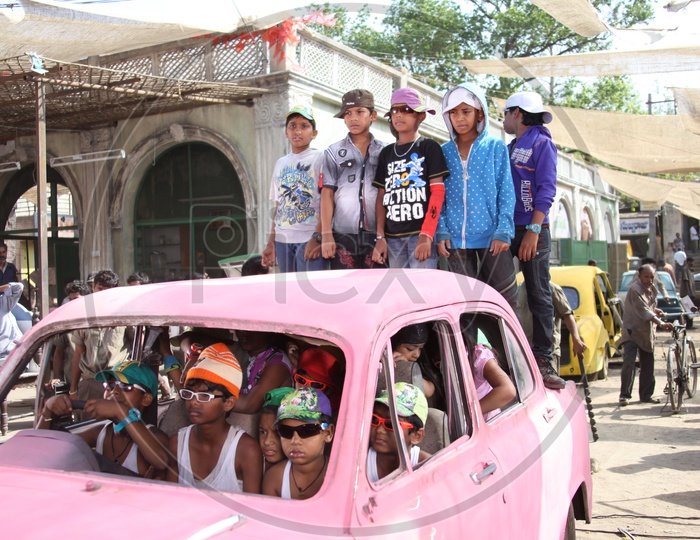 Indian Kids wearing western costumes  on a car