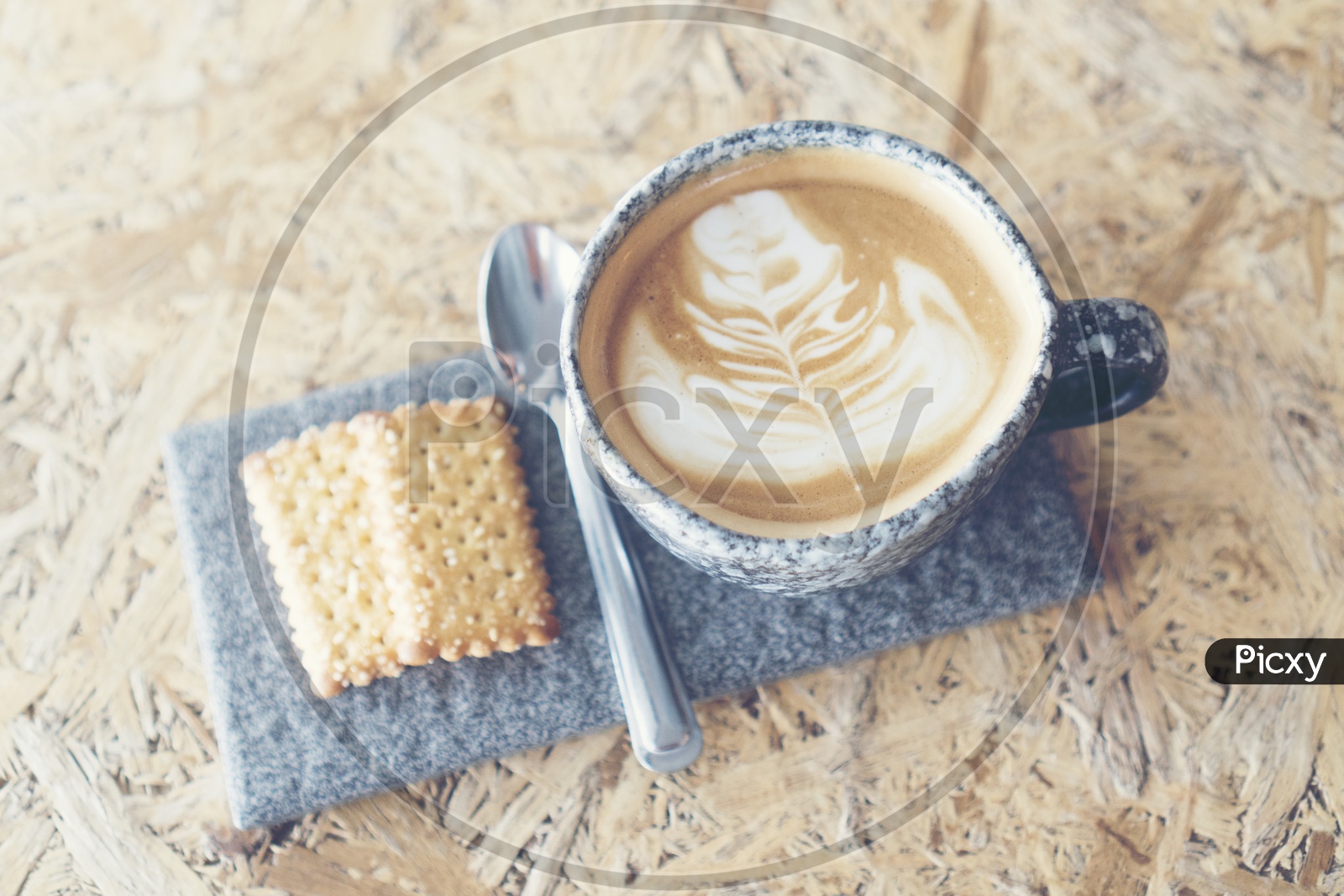coffee latte art On Coffee Cup Served With Sugar Coated Coconut Biscuits