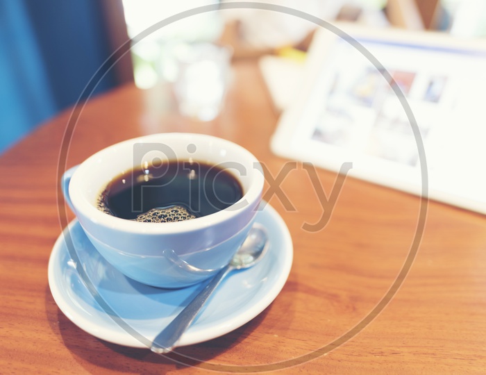 Close up of Black americano coffee in ceramic white cup on a wooden table