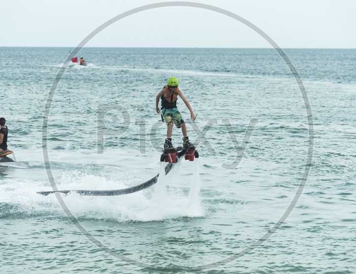 An unidentified guy is playing with a new water sport called fly board at bay in Phuket, Thailand