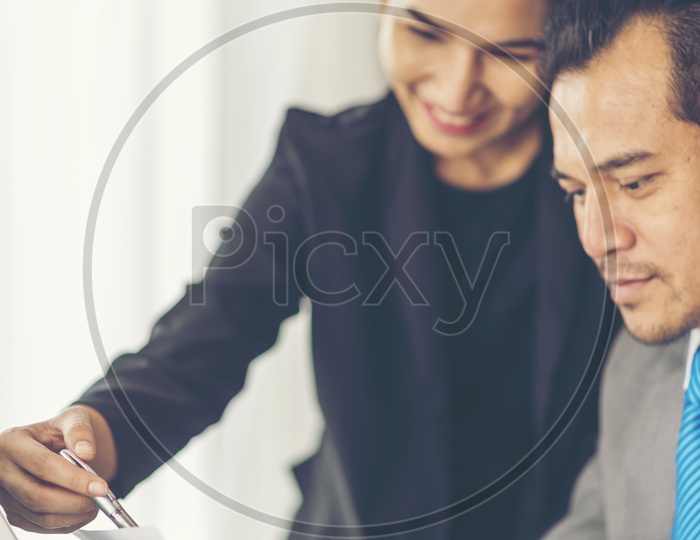 Employees Discussing Business Plans or Progress in Office Desk Background