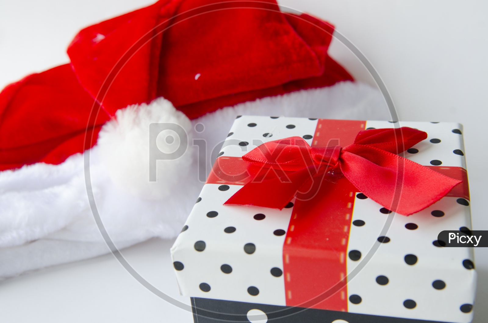 Present for Christmas With gift Box and Santa Hat On an Isolated White background