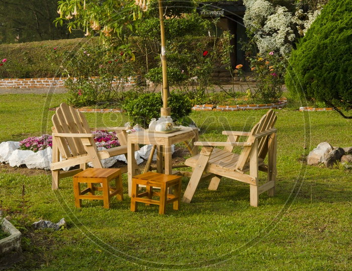 dining table with chairs and parasol in the shade in a lush garden