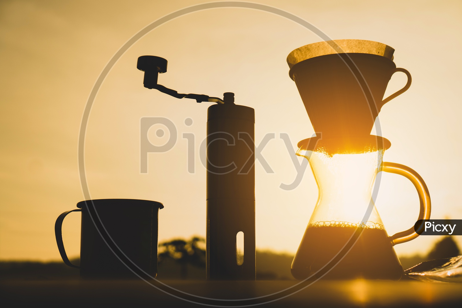 Silhouette of Coffee Drip Tools Over a Sunset background