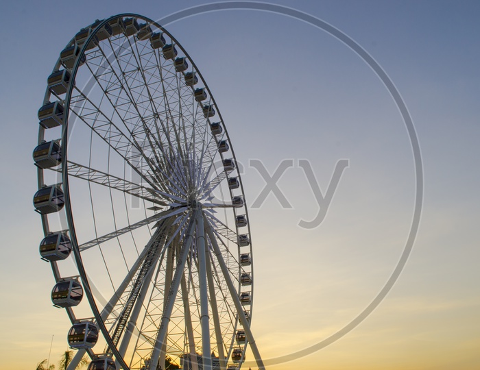 Ferris Wheel in a Fair With Golden Sunset Sky in Background