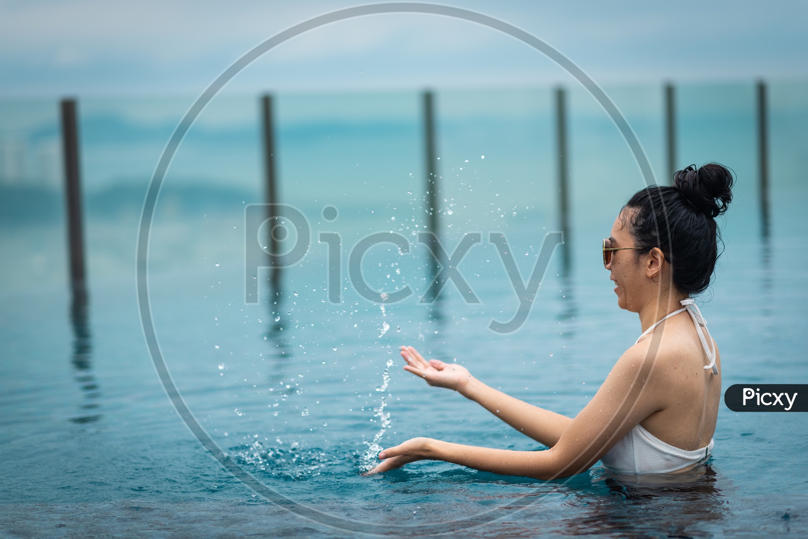 woman relaxing in swimming pool By Playing With Water